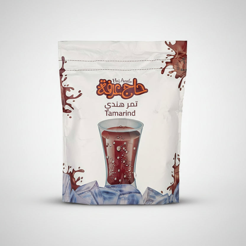 Haj Arala tamarind drink package with a glass of tamarind juice on a white background عصير تمر هندي