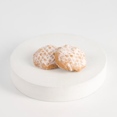 Two powdered sugar-coated cookies on a white plate with a white  background Kahk - Tseppas